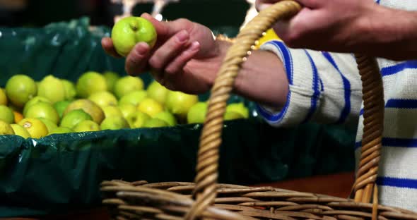 Man with a basket selecting fruit in organic section