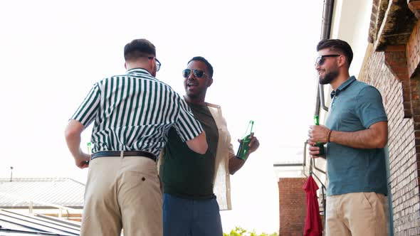 Happy Male Friends Drinking Beer at Rooftop Party