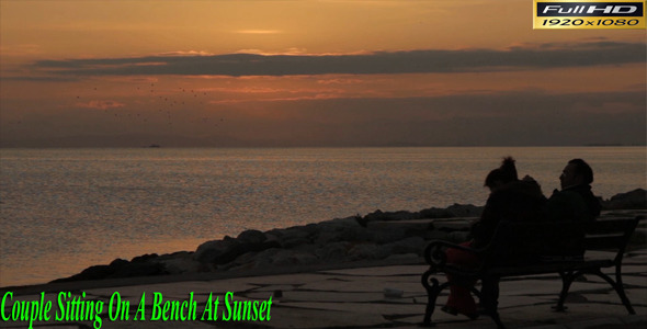 Couple Sitting On a Bench At Sunset