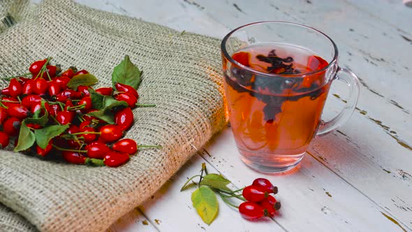 Natural Tea From Wild Rose Berries On Vintage Wooden Boards. The Red Berry Is Used In Homeopathy