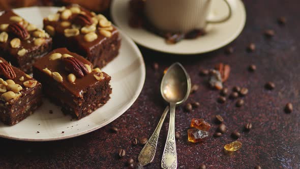 Chocolate Cake with Caramel Frosting, Pecans and Hot Coffee, on Rustic Background. Freshly Baked