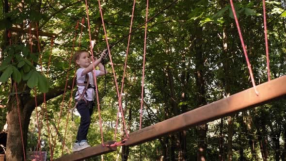 Little Boy Who Climbs on a Rope the Way To the Amusement Park in the Summer