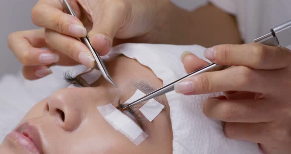 Female woman having eye lash extension in beauty salon