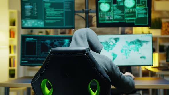 Masked Hacker in His Apartment Looking Into the Camera