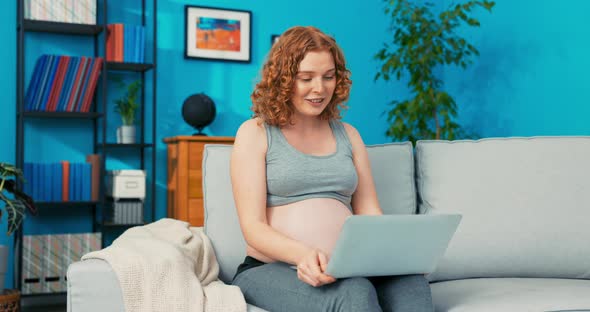 Female in Pregnancy Sitting on Couch Relaxing Talking Through Laptop Camera with Her Beloved Father