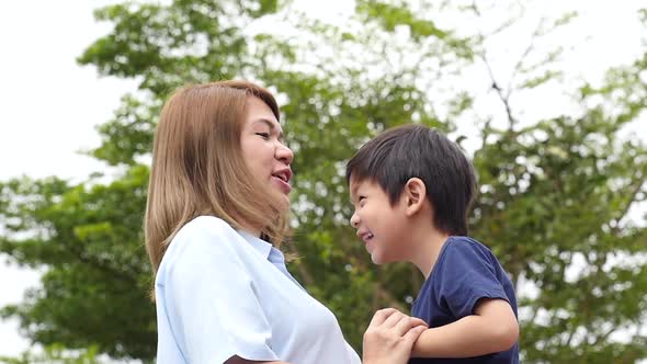 Asian Mother Carry Herson In The Park On Summer Day Slow Motion 