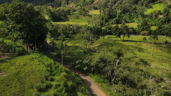 Aerial footage of drone following a vehicle driving through the central American jungle in 4k. Slow