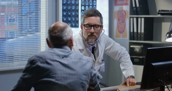 Male Doctor Examining Patient with Stethoscope