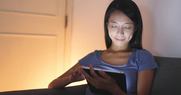 Asian woman using tablet computer at night 