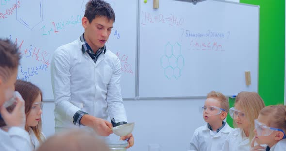 Teacher Explaining an Experiment to a High School Chemistry Class Together