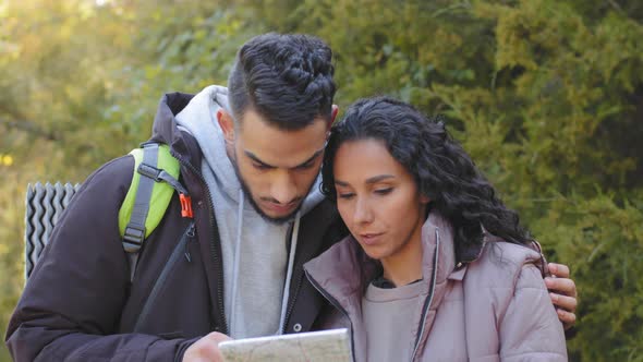 Closeup Young Married Couple in Love Tourists Standing Outdoors Looking at Paper Map Discussing