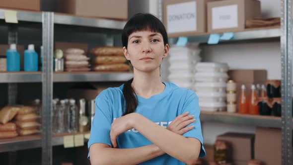 Female Volunteer Posing with Crossed Arms at Warehouse