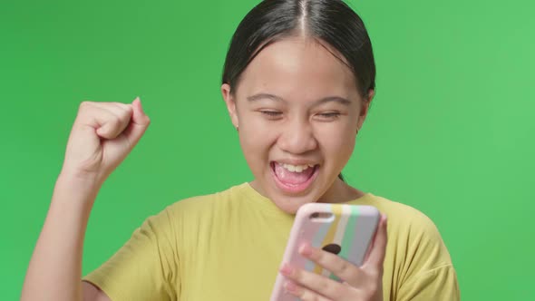 Young Asian Kid Girl Surprise And Say Wow During Use Mobile Phone While Standing On Green Screen