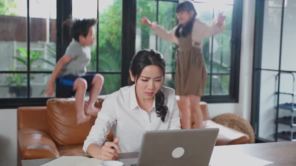 Asian mother work at home, loss her concentration on job in computer because the kids making noise.