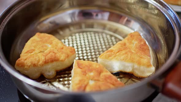 Meat Pies are Fried in Oil in a Round Saucepan