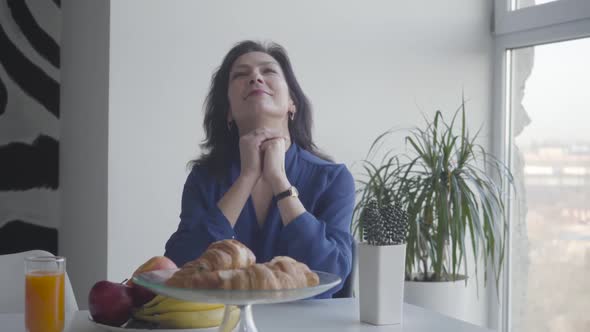 Portrait of Smiling Brunette Caucasian Woman Enjoying Morning at Home. Beautiful Adult Lady Sitting