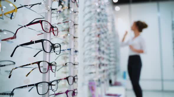 Eyeglasses concept. Fashionable glasses with colored frame on the stand in the optical store.