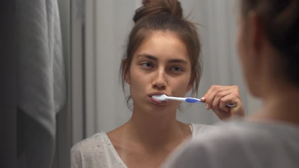 Woman Brushing Teeth in Bathroom