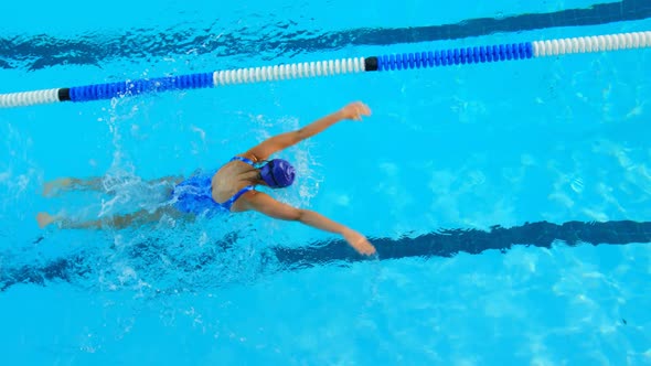 High angle view of young female swimmer swimming inside pool 4k