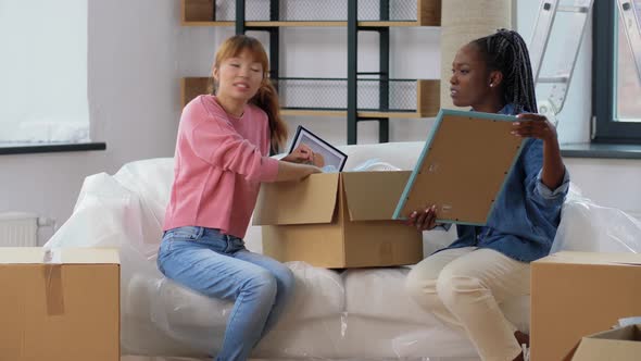 Women Unpacking Boxes and Moving to New Home