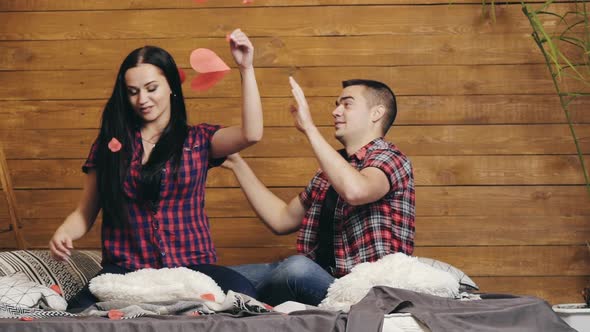 Enamored Man and Woman are Sitting on the Bed  on Valentine's Day