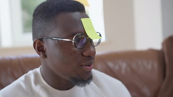 Closeup of African American Millennial Man Guessing Stone Word Playing with Friends Indoors