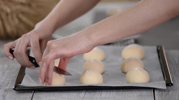 Close Up of Cuts Are Being Made on the Bun By Female Baker