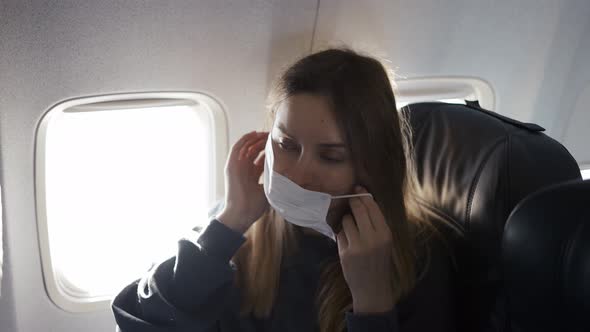 Blonde Woman Putting on Mask on Plane and Smiling
