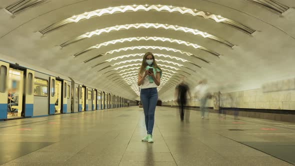 Woman in Mask in Underground Using Smartphone During Coronavirus Pandemic