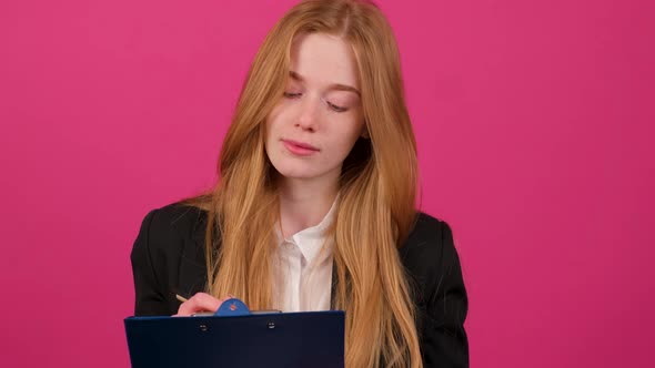 Close Up of a Businesswoman Write on a Paper Isolated on Pink Background