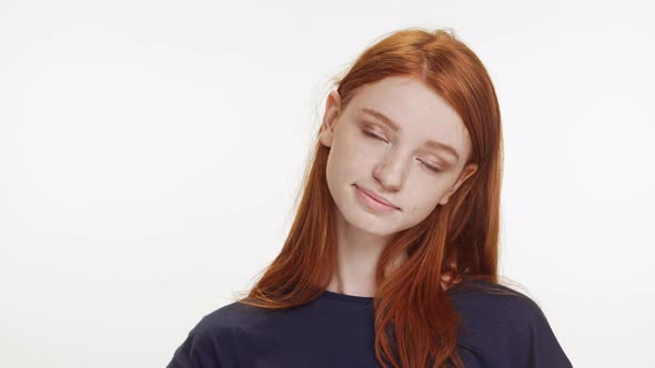 Smiling Charming Caucasian Teenage Ginger Girl in Dark Blue Tshirt Standing on White Background
