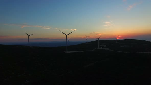 Aerial view of white elegant windmills at sunset