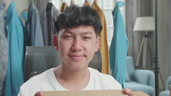 Close Up Of Asian Man Online Seller With Package Look At Camera And Smile While Selling Clothes