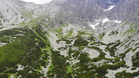 AERIAL: Reveal Shot of a Valley with a lake near the Mountain