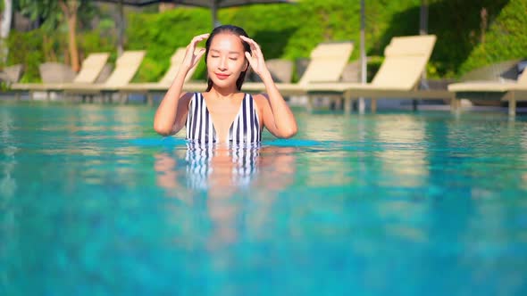 Young asian woman enjoy around outdoor swimming pool for leisure