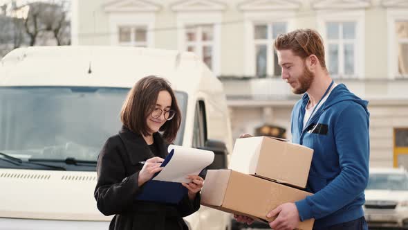 Delivery Man Giving Parcel To Happy Female Client Outdoor