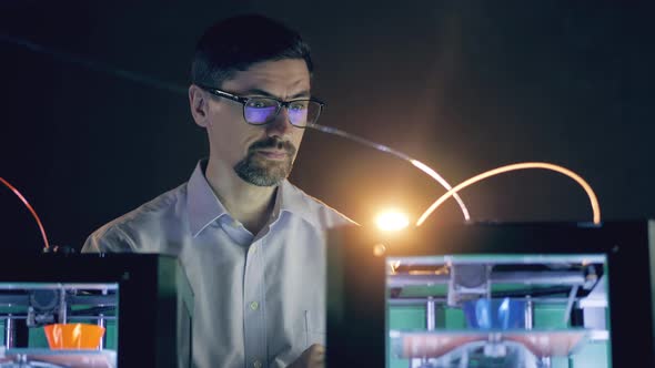 Male Engineer Is Examining 3D-printers at Work