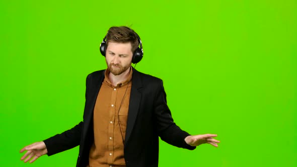 Guy Listens To Music in Headphones and Dances. Green Screen