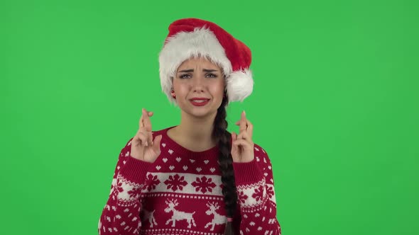 Portrait of Sweety Girl in Santa Claus Hat Is Looking at Camera with Anticipation, Then Very Upset