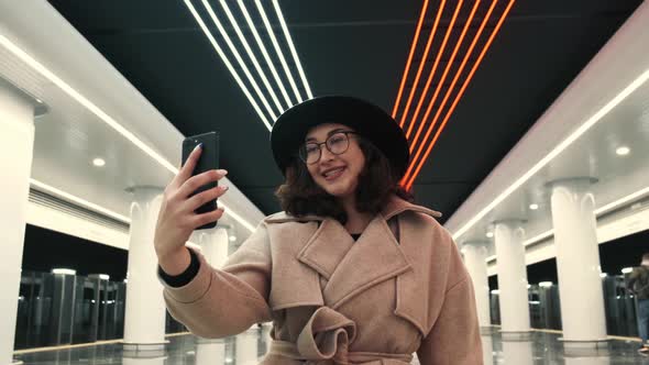 A Pretty Young Girl of European Appearance Communicates Via Video Link Via a Subway Phone