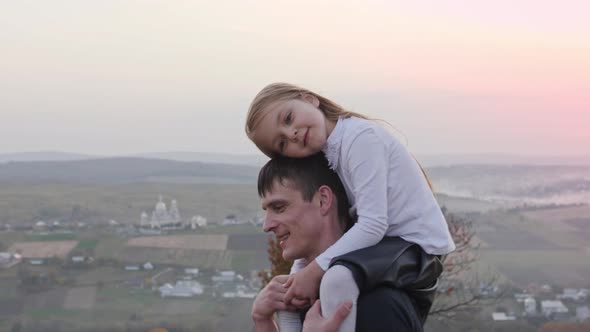 Happy Father and Little Daughter Walking in Autumn Meadow and Having Fun