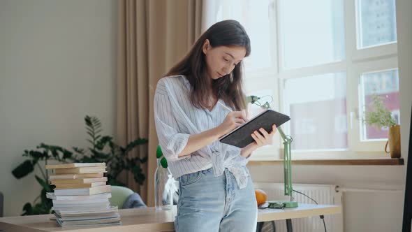 Young Beautiful Businesswoman Making Notes in a Tablet with a Stylus