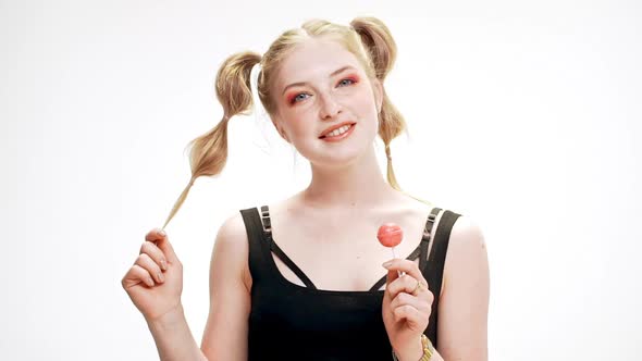 Young Beautiful Girl Smiling Winking Holding Chupa Chups Over White Background