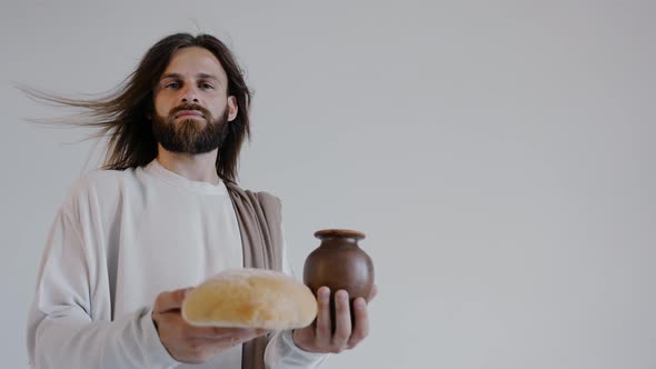 Jesus is Holding a Jug and Bread on a White Background