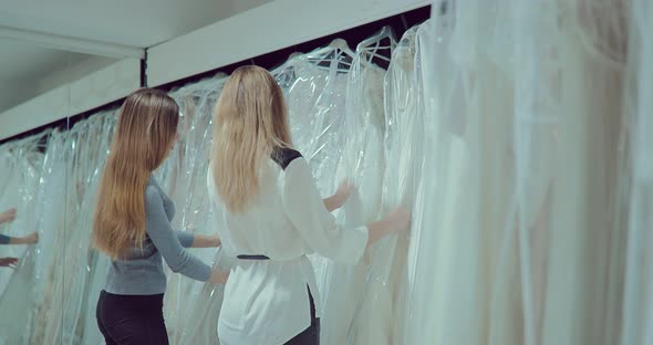 Bride and Girlfriend Choose a Wedding Dress in the Cabin