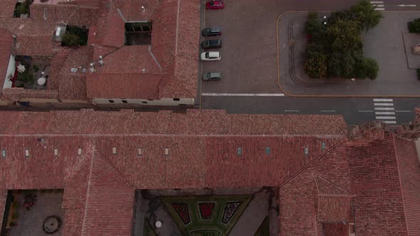 4K aerial view over a beautiful decorated inside garden of a spanish colonial house revealing the Pl