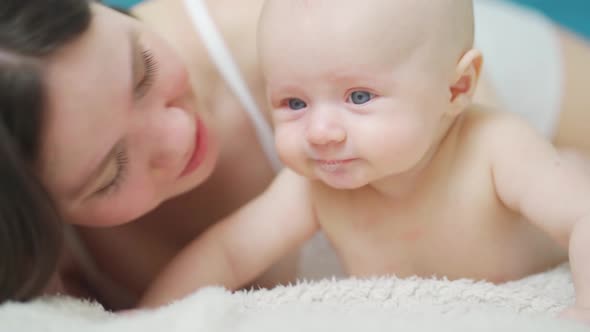 Mom Hugs and Wipe Drool the Baby on the Bed