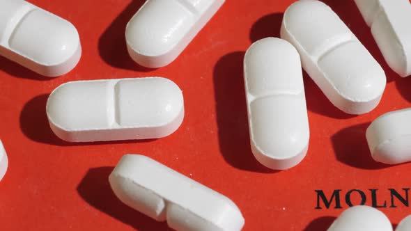 Closeup Shot of White Tablets on Red Background with Black Text