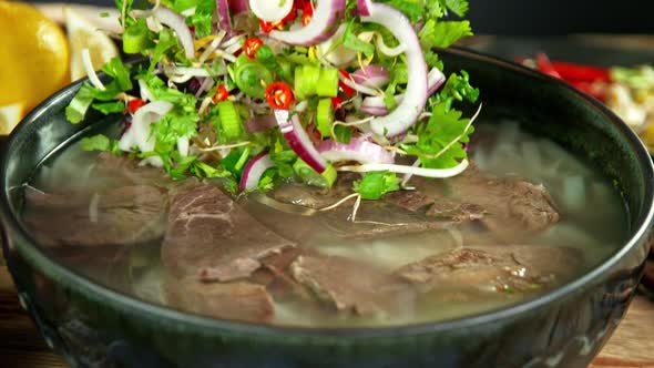 Super Slow Motion Detail Shot of Ingredients Falling Into Beef Pho Soup at 1000 Fps