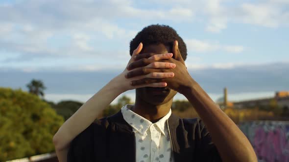 Man holding woman's hand in front of his face